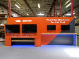 Custom Inline Exhibit with (4) Monitor Mounts, Backlit Logo, Locking Storage, and Shelves