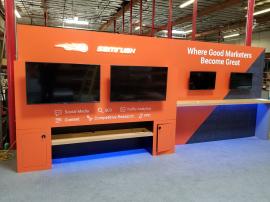 Custom Inline Exhibit with (4) Monitor Mounts, Backlit Logo, Locking Storage, and Shelves