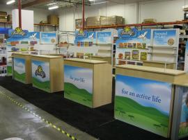 ECO-CUSTOM (4) 10X10 with Custom Eco Panel Podiums, SEG Fabric Graphics, LED Lighting and GreenCore Headers -- Image 1