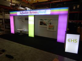 RENTAL: Custom Design with Backlit Header and Columns, Tension Fabric Backwall, RE-703 Charging Station, RE-1566 Backlit Reception Counter, and Direct Print Stand-Off Graphics