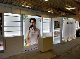 Custom Inline Exhibit with Extensive Shelving, Backlighting Including Backlit Graphics, Locking Storage, Full Closet, and Reception Counters