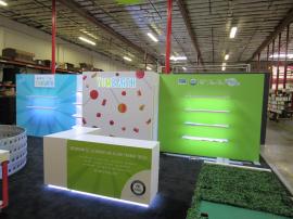 Custom Inline Exhibit with Gravitee and Custom Construction. Design Includes Backlit Logo, Shelves, LED Edge Lighting, Reception Counters with Storage, Closet, and Fabric and Direct Print Graphics