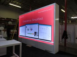 Custom Island Exhibit with Double-sided Lightboxes, Backlit Reception Counter, Two-sided Workstation Counters, Monitor Mounts, and Locking Storage