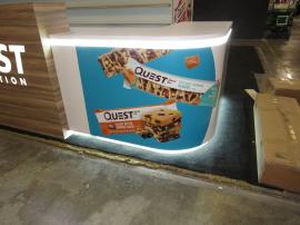 Custom Island Exhibit with Custom Counters, LED Perimeter Lighting and Logos, Locking Storage, Product Shelves, and Reception Counter