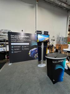 RENTAL: RE-1089 10 x 10 Inline Design with (2) LED Arm Lights, RE-1212 Kiosk with Monitor Mount, 32 inch Monitor, SEG Fabric Graphics, Direct Print Sintra Accent Wing Graphics, and Vinyl Applied Counter Graphic.
